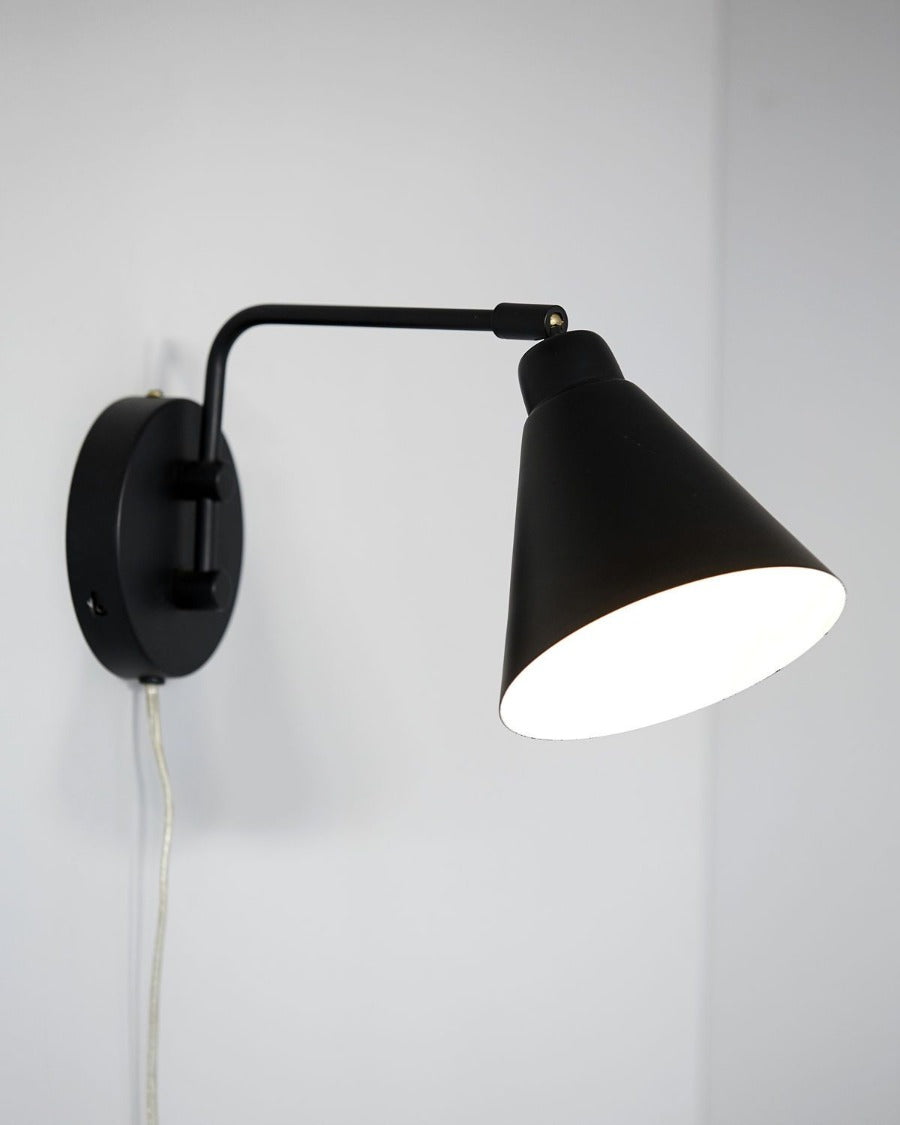 Game is a stunning wall light that is made with a modern style in mind. The black lamp is made of iron, which adds character and personality to the look. Hang the light in your bedroom as a decorative bedside lamp, or hang it on the wall in your living room as an exciting and new source of light.